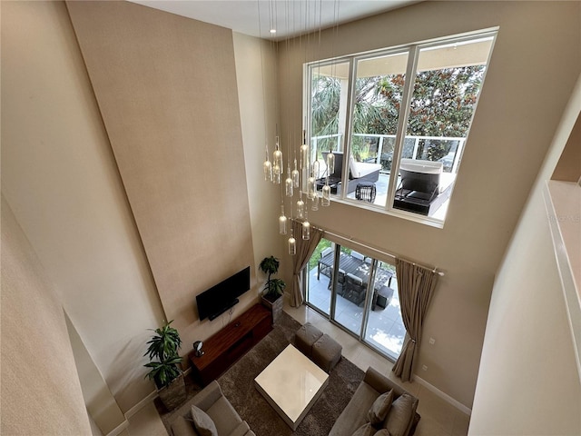 living area featuring a high ceiling and baseboards