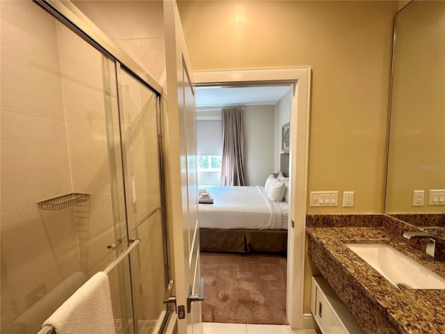 bathroom with walk in shower, vanity, and tile patterned flooring