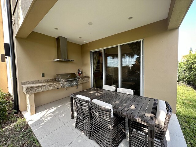 view of patio / terrace with a grill, outdoor dining space, and exterior kitchen