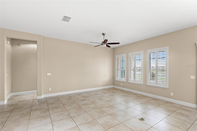 spare room featuring light tile patterned flooring, visible vents, baseboards, and ceiling fan