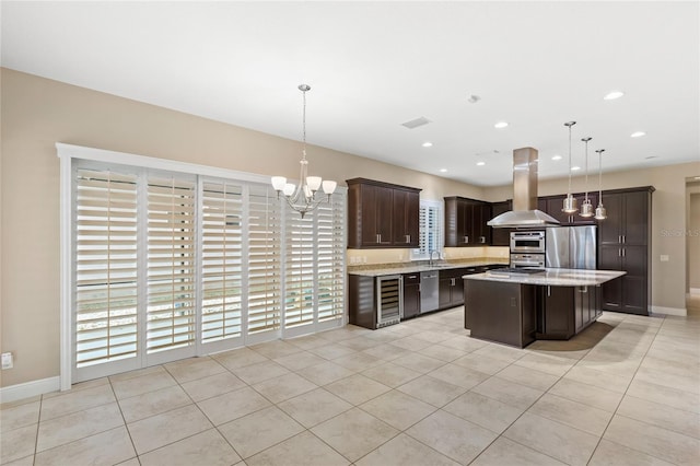 kitchen featuring island range hood, beverage cooler, dark brown cabinets, appliances with stainless steel finishes, and a chandelier