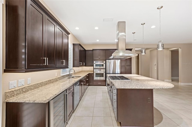 kitchen featuring a kitchen island, wine cooler, appliances with stainless steel finishes, island range hood, and arched walkways