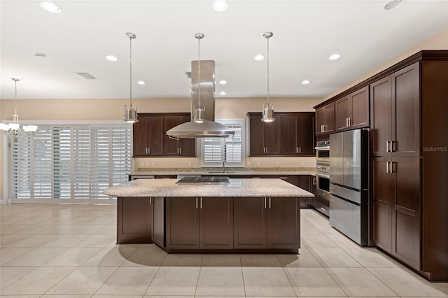 kitchen with visible vents, a kitchen island, appliances with stainless steel finishes, light stone countertops, and dark brown cabinets