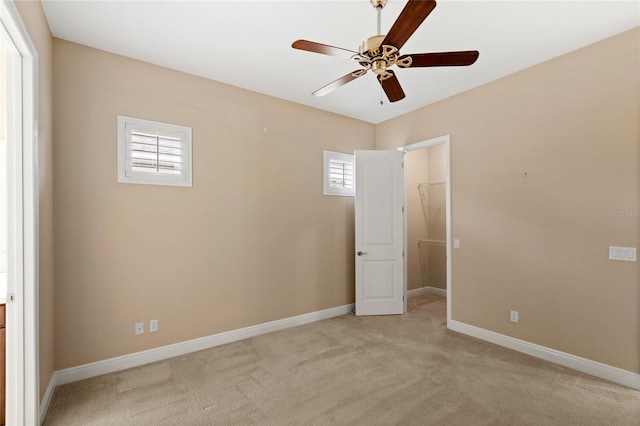 empty room with baseboards, light colored carpet, and ceiling fan