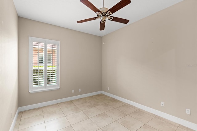 spare room featuring light tile patterned flooring, baseboards, and ceiling fan