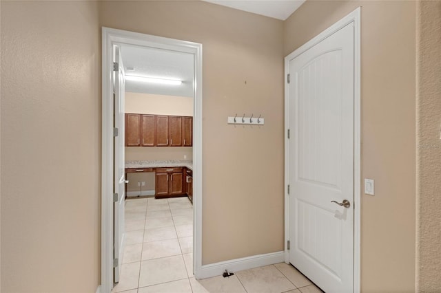 hall with light tile patterned floors and baseboards