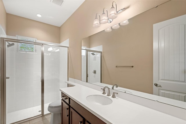 full bathroom featuring vanity, a shower stall, toilet, and visible vents