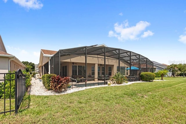 back of house featuring glass enclosure, a patio, a lawn, and ceiling fan