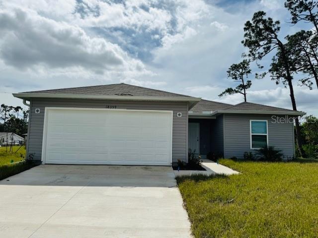 ranch-style home with a front yard, driveway, and a garage