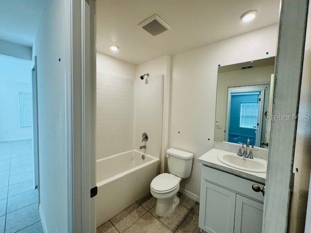 full bathroom with tile patterned floors, shower / bathing tub combination, toilet, vanity, and visible vents