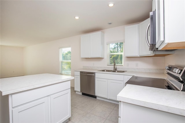 18059 Regan Ave, Port Charlotte, FL 33948 - kitchen with a sink, stainless steel appliances, white cabinetry, light tile patterned floors, and light countertops