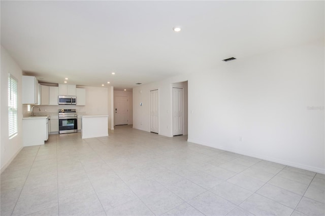 18059 Regan Ave, Port Charlotte, FL 33948 - unfurnished living room with a sink, recessed lighting, and baseboards