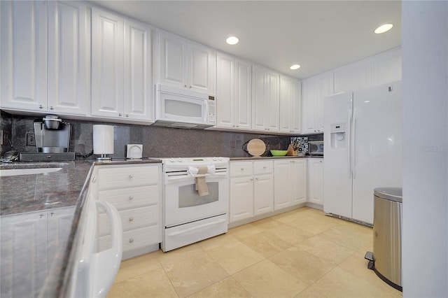 kitchen with white appliances, decorative backsplash, and white cabinetry