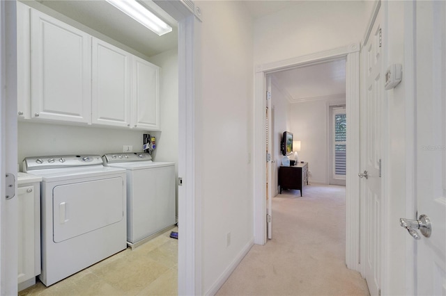 washroom with light carpet, cabinets, and washing machine and dryer