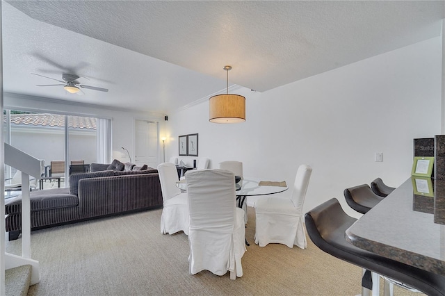 dining area featuring ceiling fan, a textured ceiling, and carpet floors