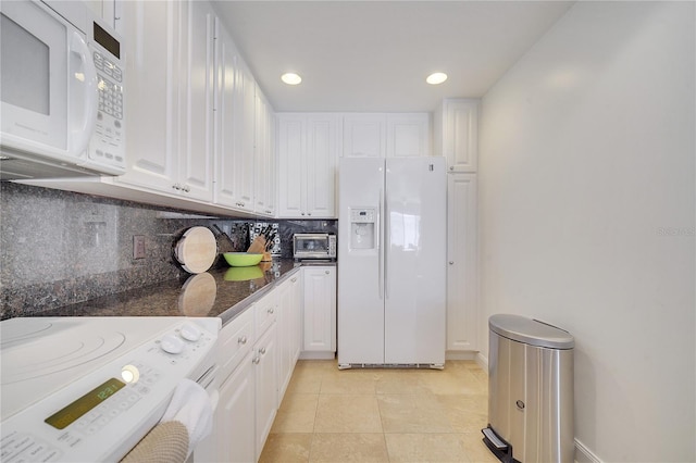 kitchen featuring washer / dryer, white appliances, decorative backsplash, and white cabinetry