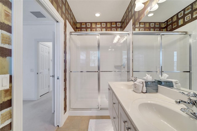 bathroom featuring a shower with door and vanity