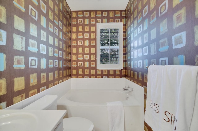 bathroom with vanity, toilet, and a tub