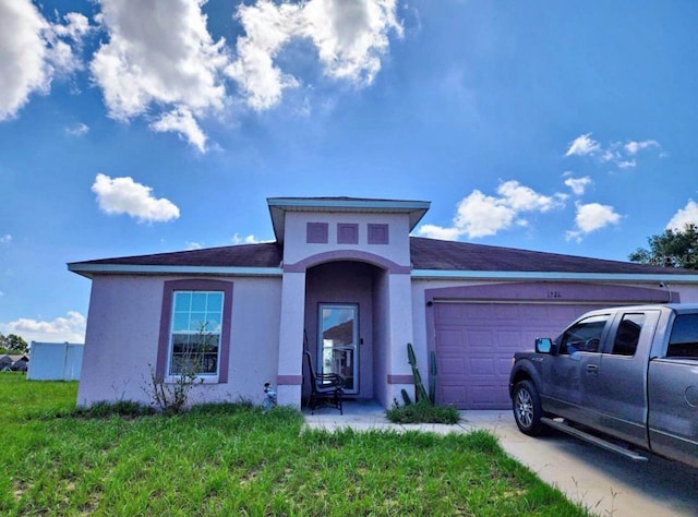 view of front of home with a garage and a front lawn