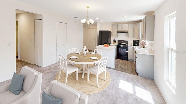 dining space with a notable chandelier, sink, and hardwood / wood-style floors