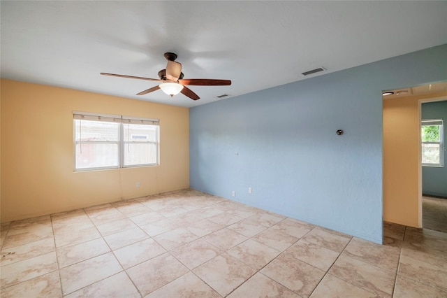 spare room with ceiling fan and light tile patterned floors