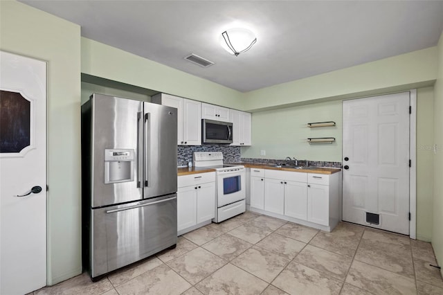 kitchen featuring wood counters, visible vents, white cabinets, appliances with stainless steel finishes, and open shelves