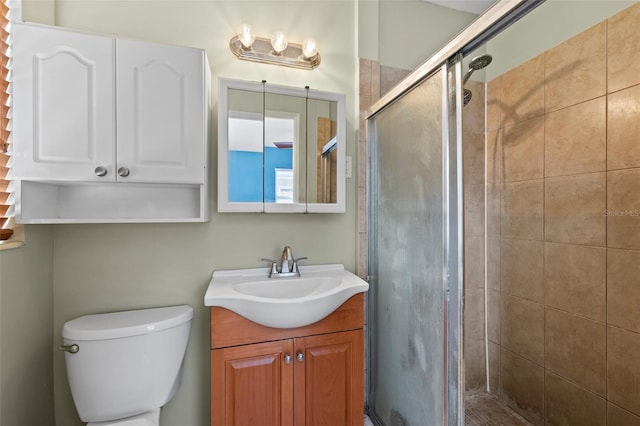 full bathroom featuring a stall shower, vanity, and toilet