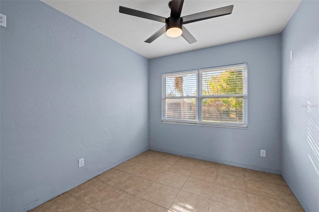 spare room with ceiling fan and a textured wall