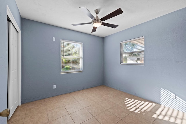 unfurnished room with ceiling fan and a textured wall