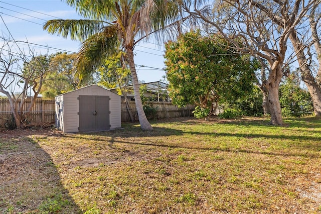 view of yard featuring a fenced backyard, a storage unit, and an outdoor structure