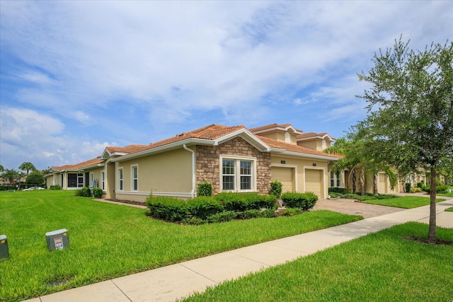 view of front of property featuring a garage, stone siding, a tile roof, a front lawn, and stucco siding