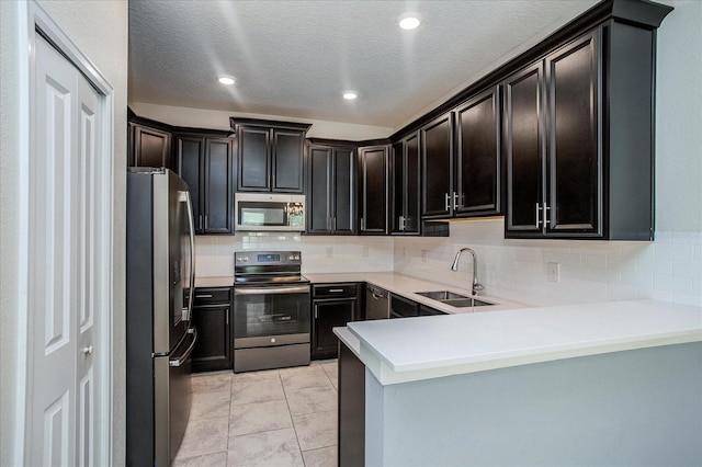 kitchen featuring kitchen peninsula, light tile patterned floors, backsplash, stainless steel appliances, and sink