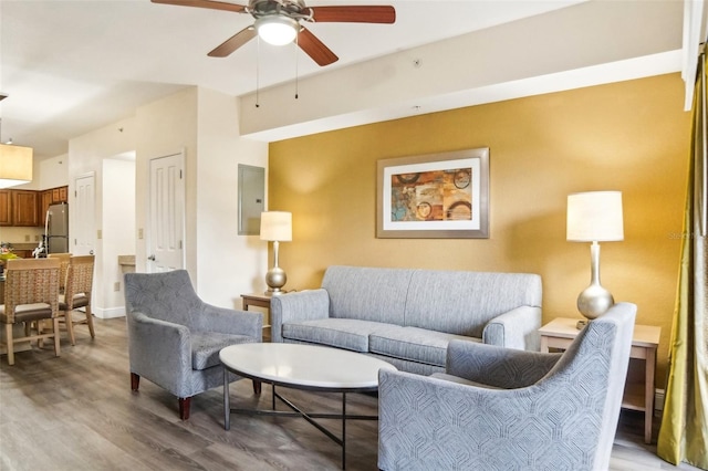 living room with electric panel, ceiling fan, and hardwood / wood-style floors