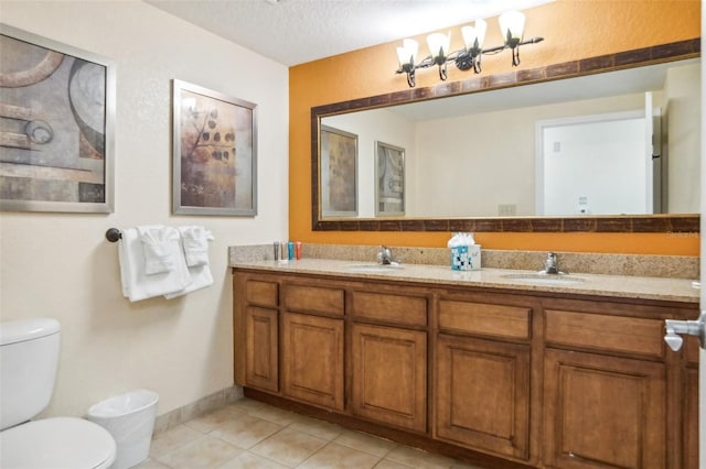 bathroom with a textured ceiling, toilet, vanity, and tile patterned flooring