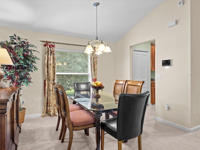 dining room featuring lofted ceiling, a chandelier, and light colored carpet