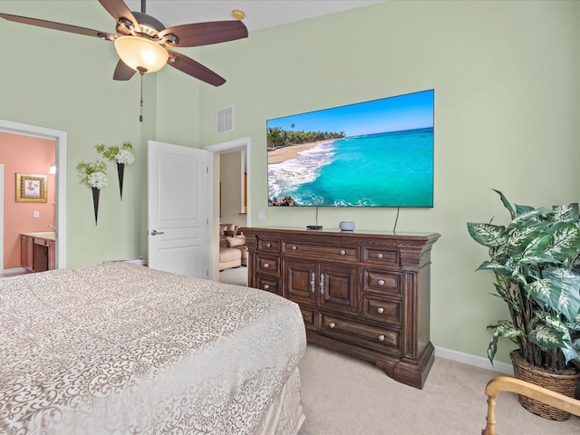 carpeted bedroom featuring ensuite bath, a towering ceiling, and ceiling fan