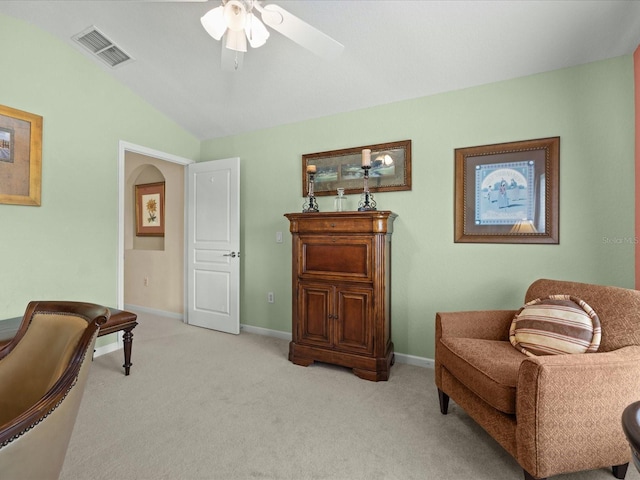 sitting room with ceiling fan, vaulted ceiling, and carpet