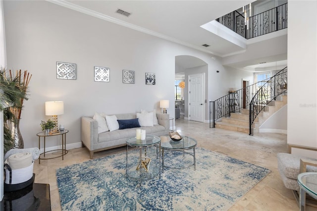 living room featuring ornamental molding, light tile patterned floors, and a high ceiling