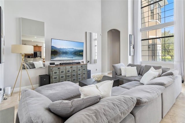 living room with light tile patterned floors and a high ceiling