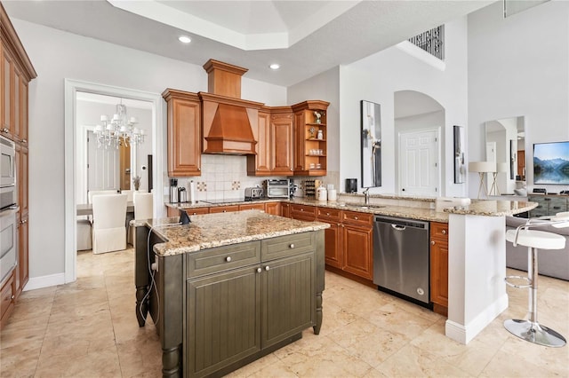 kitchen featuring custom range hood, dishwasher, a breakfast bar, a kitchen island, and light stone counters