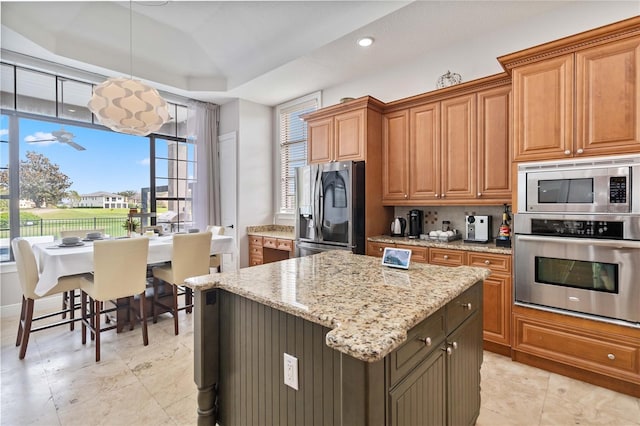 kitchen featuring a wealth of natural light, stainless steel appliances, light tile patterned floors, and a kitchen island