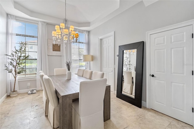 dining area featuring a raised ceiling, light tile patterned floors, and an inviting chandelier