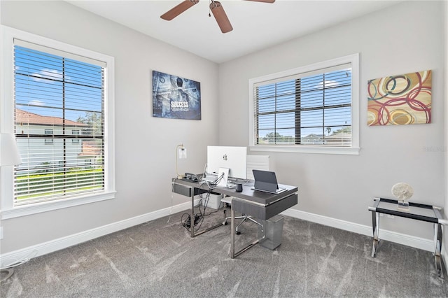 office area with ceiling fan, dark carpet, and plenty of natural light