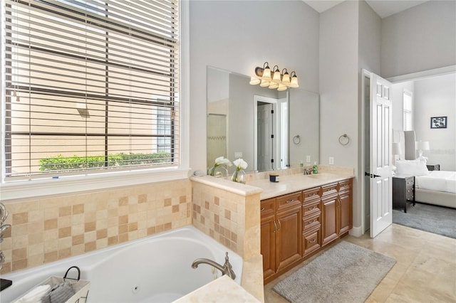 bathroom with a towering ceiling, vanity, a relaxing tiled tub, and tile patterned flooring