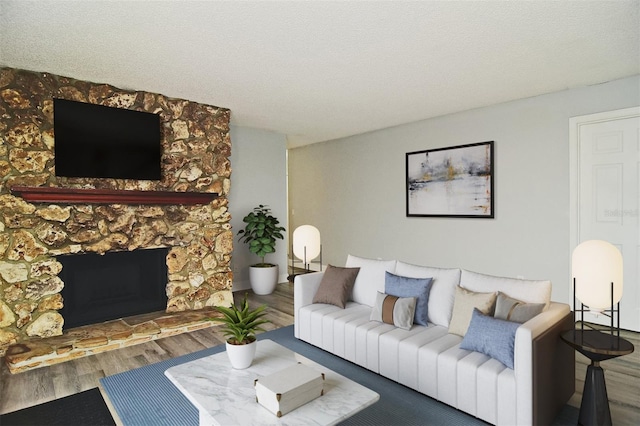 living room featuring a stone fireplace, a textured ceiling, and hardwood / wood-style floors