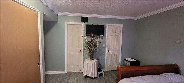 bedroom with ornamental molding, dark hardwood / wood-style floors, and a textured ceiling