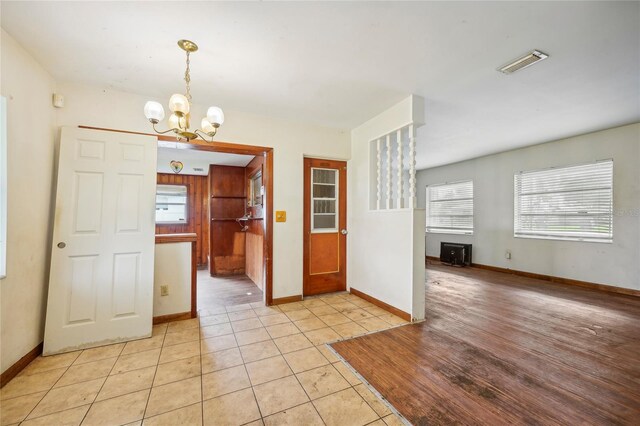 unfurnished dining area featuring light tile patterned floors and a chandelier