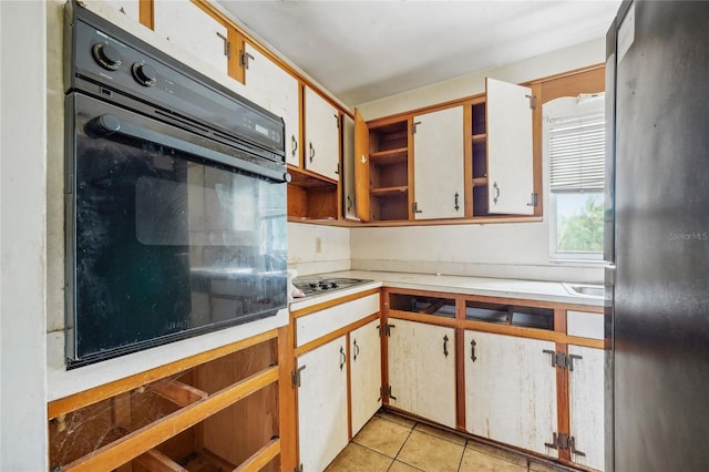 kitchen featuring white cabinetry, light tile patterned floors, gas cooktop, and oven