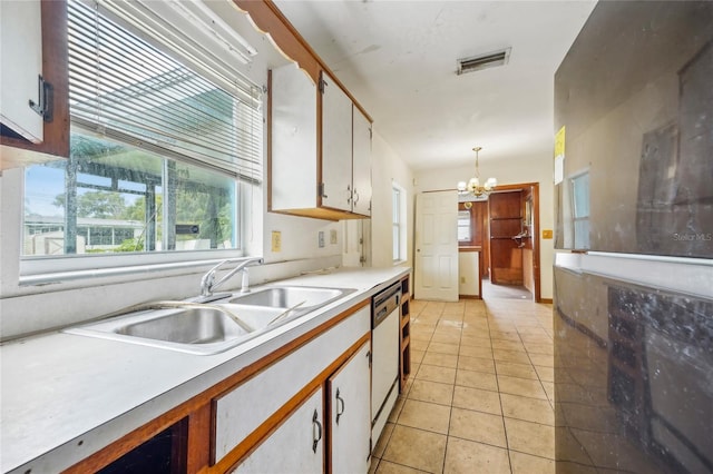 kitchen with hanging light fixtures, sink, dishwashing machine, and white cabinets