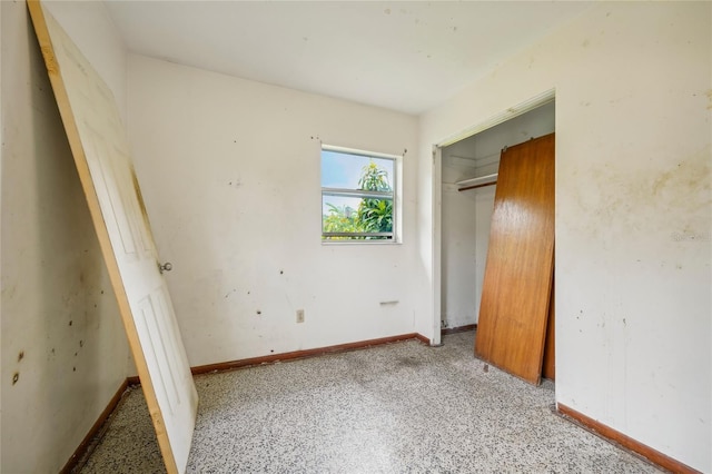 unfurnished bedroom featuring light carpet and a closet